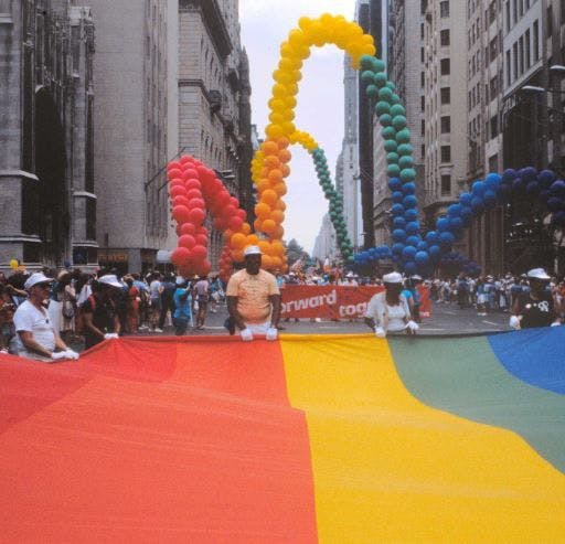 Picture of NYC Pride Parade with flag and balloons